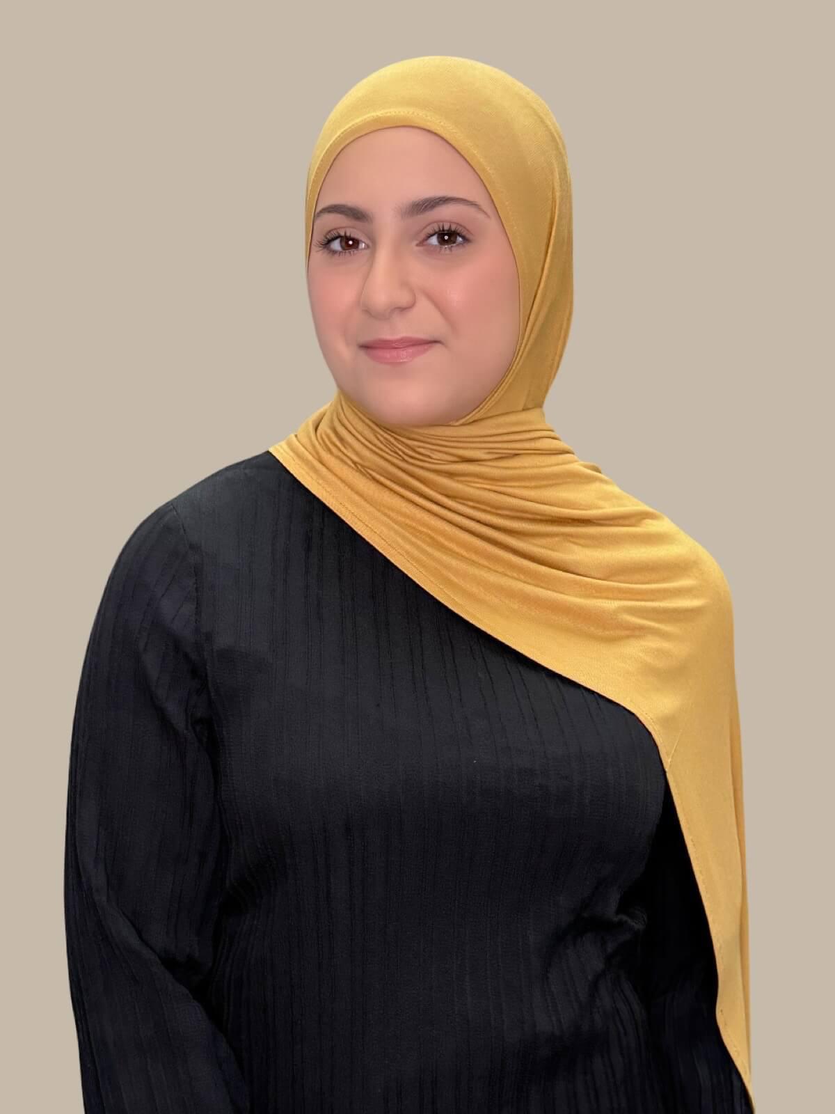 Saffron Pre-Sewn Jersey Hijab in Modish Girl size, front view on model with hijab draped over shoulder showing smooth fit and soft stretch fabric.
