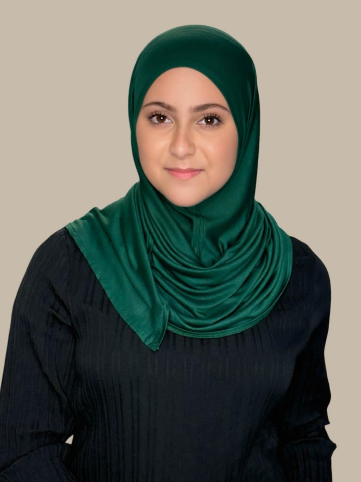 Pine Green Pre-Sewn Jersey Hijab in Modish Girl size, front view on model with hijab wrapped neatly around shoulders showing smooth fit and soft stretch fabric.
