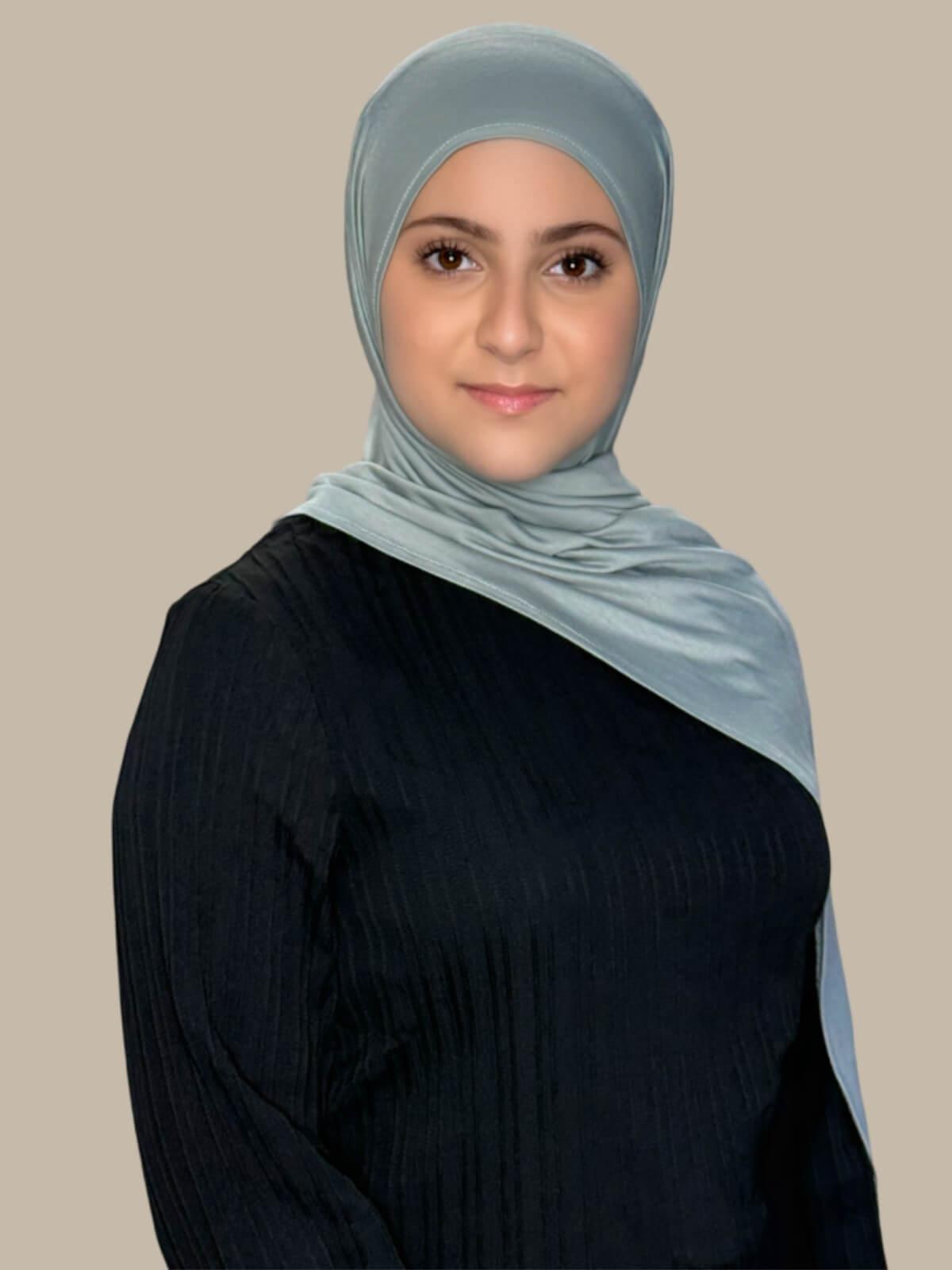 Stone Green Pre-Sewn Jersey Hijab in Modish Girl size, front view on model with hijab draped over shoulder showing smooth fit and soft stretch fabric.