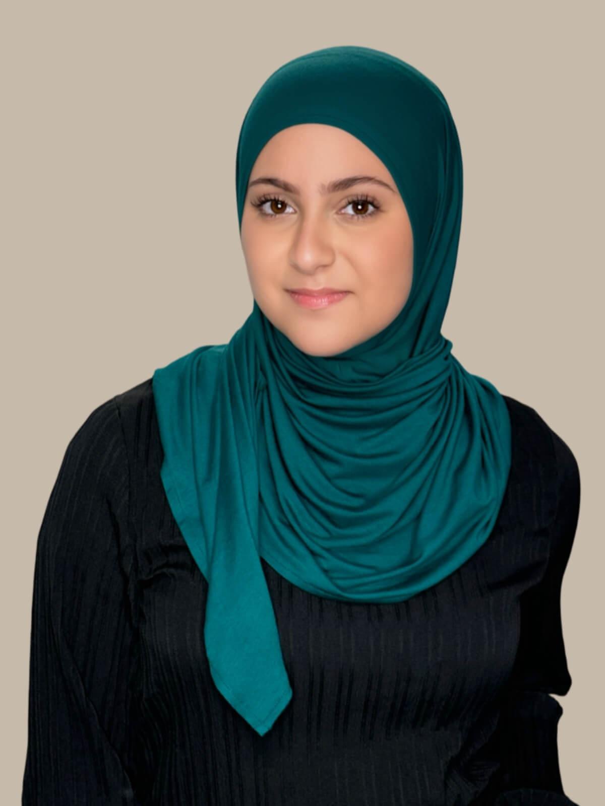 Pine Green Pre-Sewn Jersey Hijab in Modish Girl size, front view on model with hijab wrapped neatly around shoulders showing smooth fit and soft stretch fabric.