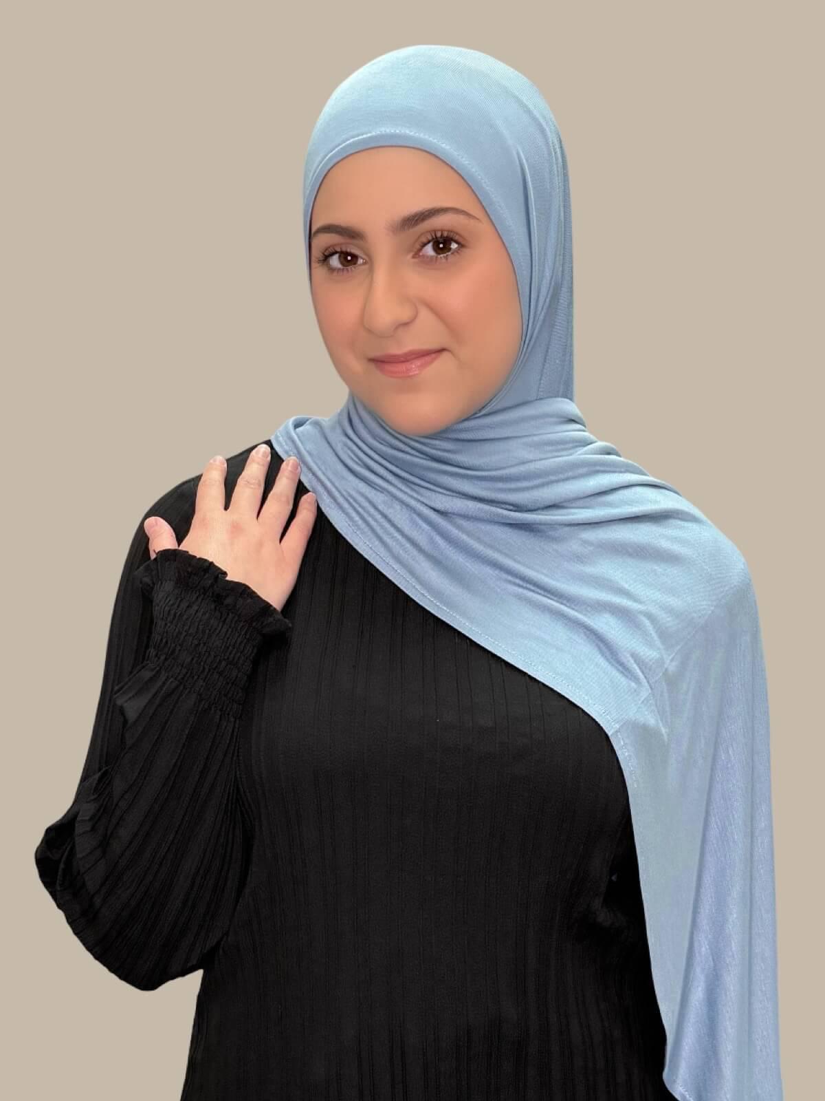 Dusty Blue Pre-Sewn Jersey Hijab in Modish Girl size, front view on model with hijab draped over shoulder showing smooth fit and soft stretch fabric.