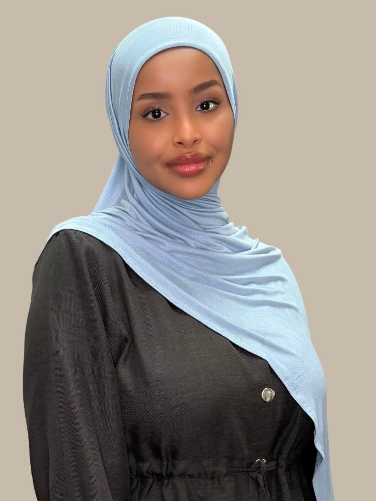 Dusty Blue Pre-Sewn Jersey Hijab, front view on model draped over shoulder. No pins